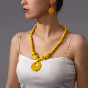 Set collana e orecchini di perle di legno giallo fatte a mano, gioielli donna dettaglio.