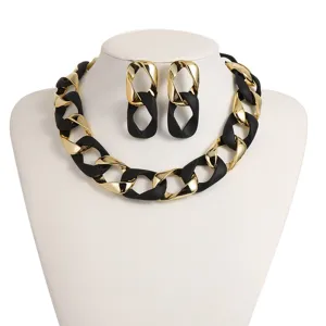 Chunky chain necklace and matching earrings set, black and gold stylish fashion jewelry detail.