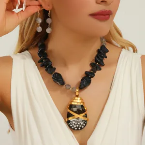 Detail shot of trendy European style black stone crystal pendant necklace and earrings.