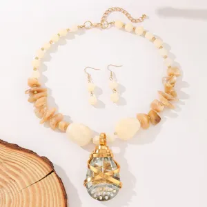 Detailed view of fashion teardrop crystal pendant necklace and earrings set with chips.
