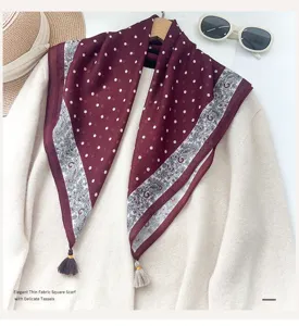 Foulard carré à pois français avec de délicates pompons et bordure paisley élégante.