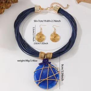 Vista di dettaglio del set collana con ciondolo in resina blu e orecchini geometrici.