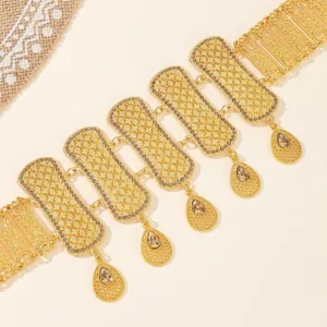 Gold metal waist chain detail featuring hollow carved links and rhinestone tassels.
