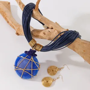 Set di gioielli con collana con pendente in pietra di resina blu e orecchini a spirale.