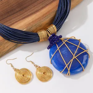 Set di gioielli con collana pendente in pietra di resina geometrica e orecchini dettagli.