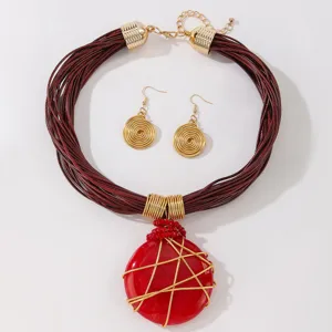 Set di gioielli alla moda con collana con ciondolo in resina e orecchini a spirale.