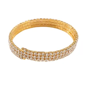 Primo piano di un bracciale da braccio dorato lucido a 3 file di strass con bei cristalli.