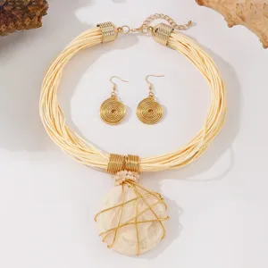 Set collana corda multi-filo e orecchini boho con ciondolo in resina avvolto dettaglio.