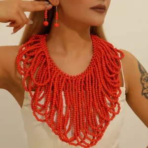 Bohemian red beaded necklace and drop earrings set, African style statement jewelry detail view.