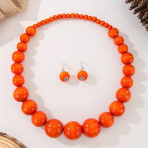 Ensemble de bijoux collier et boucles d'oreilles en perles de bois orange bohème pour femmes.