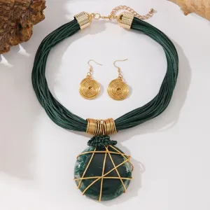 Vista dettagliata di una collana in corda verde multi-filo e orecchini con pendente in filo.