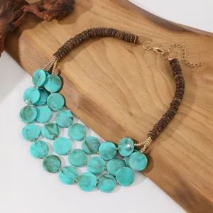Meerlaagse statement ketting met turquoise acryl schijven en bruine houten kralen.