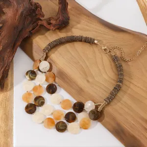 Gedetailleerd overzicht van meervoudige houten kralen en acryl ketting op houten rekwisiet.