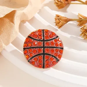 Gros plan d'une broche de basket-ball en strass rouge étincelant accessoire de mode.