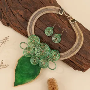 Handmade green resin leaf statement necklace and earrings set with gold wire spirals.