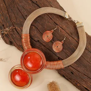 Close-up detail of statement chunky necklace and earrings set with resin stone and wire wrap.
