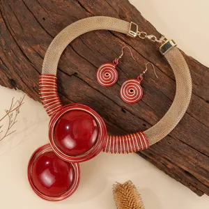 Detail shot of the red resin and gold aluminum wire statement necklace and earrings set.
