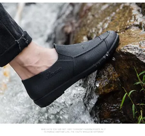 Waterproof short rain boots detail showing textured black surface and durable sole stepping on rocks.