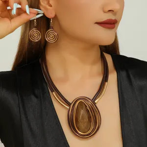 Detailed shot of trendy European resin stone pendant necklace and spiral earrings set.