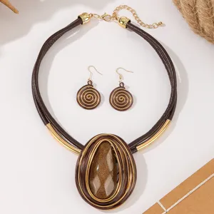 Stylish brown leather cord necklace and spiral earrings jewelry set with teardrop resin pendant.