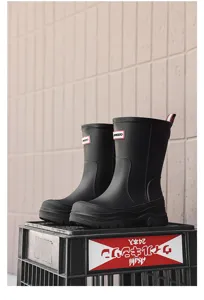 Detail view of black mid-calf rain boots, waterproof slip-on design for daily wear.
