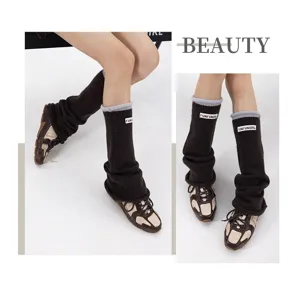 Knit leg warmers with rolled edge and label detail, cozy autumn winter accessory for women.
