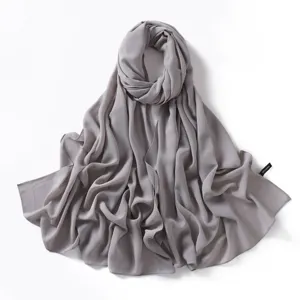 Close-up detail of the elegant grey solid chiffon scarf fabric showing smooth texture and drape.