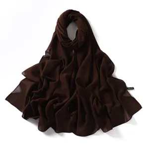 Close-up detail of smooth dark brown chiffon scarf fabric, showing soft texture and fine edge.