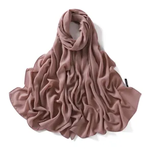 Chiffon hijab detail showing soft draped fabric texture and fine edge stitching in solid color.