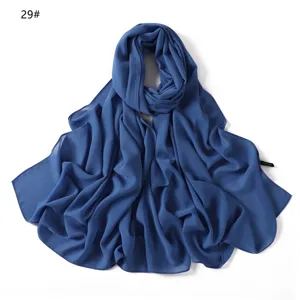Vue détaillée du long foulard en mousseline bleue avec des bords nets et un beau drapé.