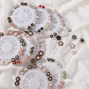 Close-up detail view of decorative floral brooch pins and pearl scarf pins on white fabric.