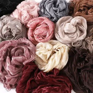 Close-up detail showing multiple colorful crinkled chiffon scarves with lettuce edge.
