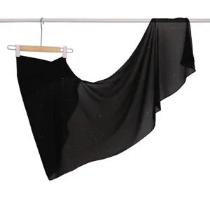 Dettaglio scialle in chiffon nero con paillettes, tessuto trasparente ed elegante.