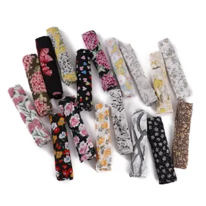 Vue détaillée de plusieurs foulards en mousseline enroulés aux motifs variés et colorés.