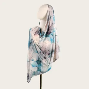 Détail du motif tie-dye abstrait sur le long foulard en coton mercerisé sur mannequin.