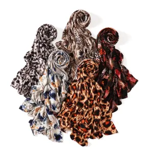 Detailed view of multiple fashionable leopard and snakeskin print long scarves for women.
