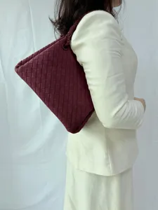Detailed view of the burgundy woven shoulder bag worn on model, showing retro style and large capacity.