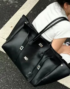 Large black leather tote bag with multiple pockets and turn-lock hardware for women commute.
