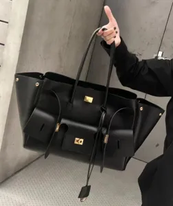 Black leather large tote bag with multi pockets and gold hardware, stylish commute shoulder bag.