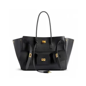 Close-up detail view of black leather tote bag featuring stylish turn-lock front pockets.