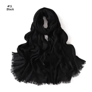 Close-up detail of black crinkled cotton linen fringed scarf, versatile stylish accessory.