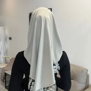 Detailed back view of a solid color crystal linen hijab with wheat lace and tassel trims.