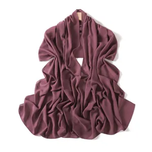 Detailed view of the dark mauve chiffon long scarf draped gracefully on a wooden hanger.