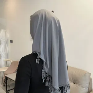 Detail shot of grey hijab with lace tassel trim, soft crystal linen fabric and elegant back view.