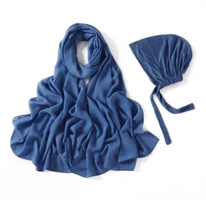 Gros plan détaillé du long foulard hijab en mousseline bleue et de son bonnet en modal.
