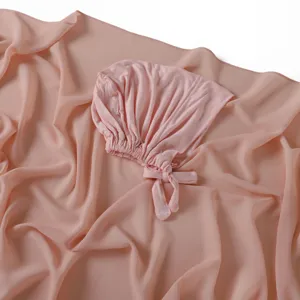 Ensemble bonnet noué en modal et écharpe en mousseline rose, texture douce, vue détaillée.