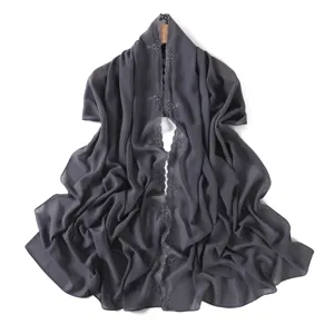 Dark grey chiffon scarf detail showing elegant floral embroidery and smooth drape texture.