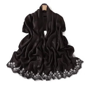 Detailed view of dark shiny long scarf with exquisite white floral embroidered edges.