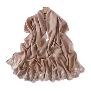 Detailed view of glossy pearlescent solid color shawl scarf with delicate white floral embroidery.