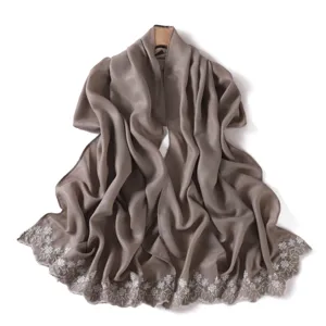 Close-up detail of the elegant floral embroidered edge and glossy silky texture scarf shawl.